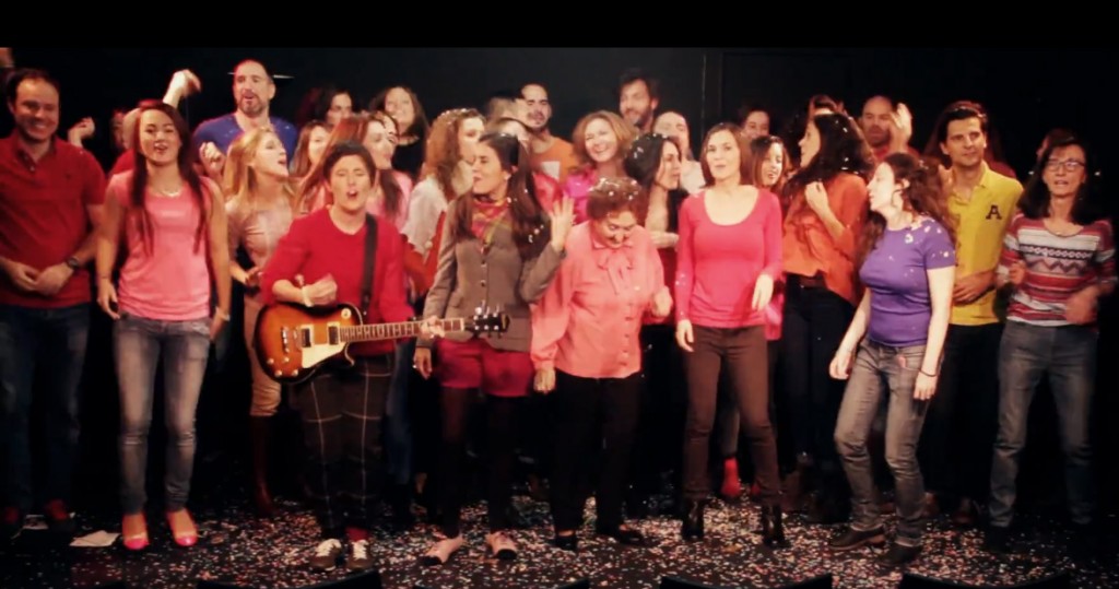 Rodaje de «Juego de maletas»: Ana y Susana con guitarra eléctrica rodeadas de decenas de figurantes en un escenario con confeti
